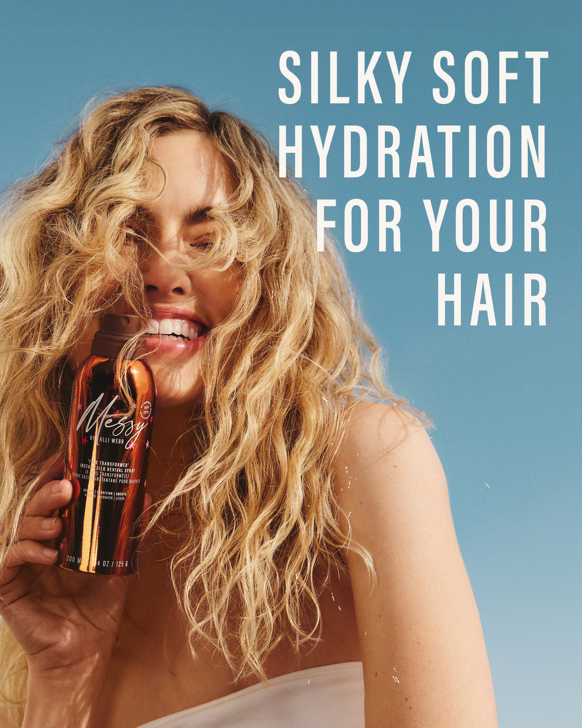 Blonde model with tousled waves holds Instant Silk Revival Spray — silky soft hydration for your hair.