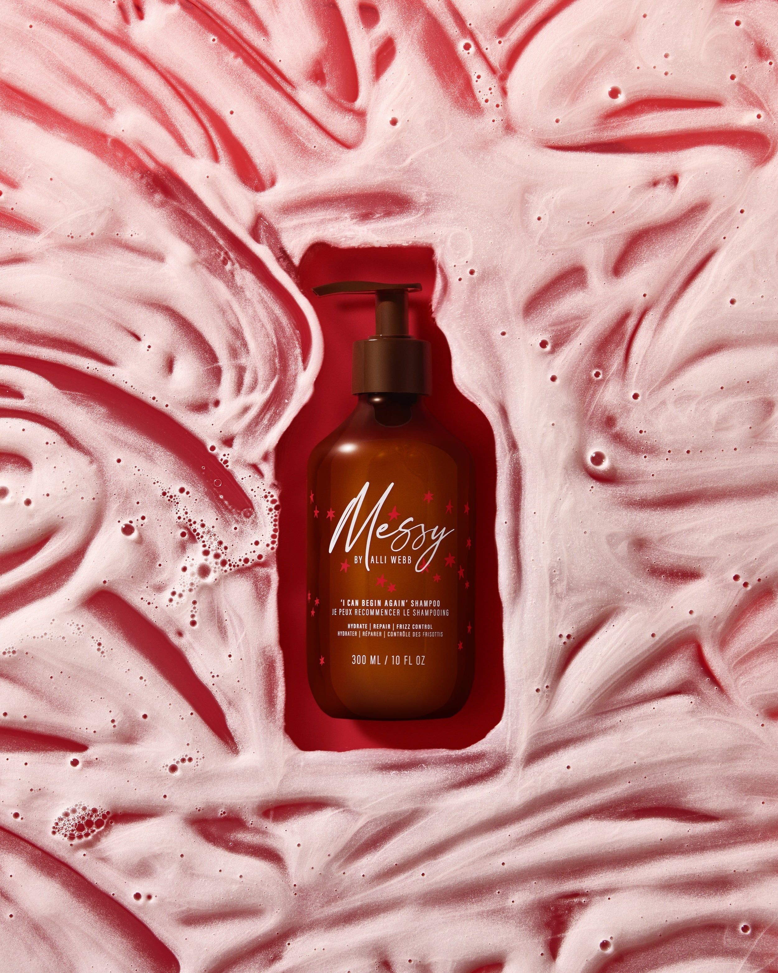 Shampoo bottle nestled in swirls of soft pink lather.
